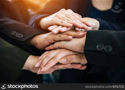 Business people making pile of hands for startup new project. Business and togetherness concept. Cooperation and Successful concept. Teamwork and Organization theme. Close up view of stacking hands.