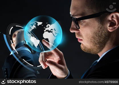 business, people, mass media and modern technology concept - close up of businessman with smartwatch and earth hologram over black background. close up of businessman with smartwatch