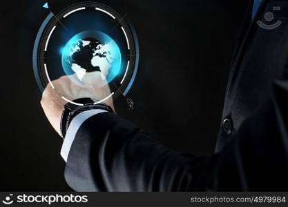 business, people, mass media and technology concept - close up of businessman hand with smartwatch and earth hologram over black background. close up of businessman hand with smartwatch