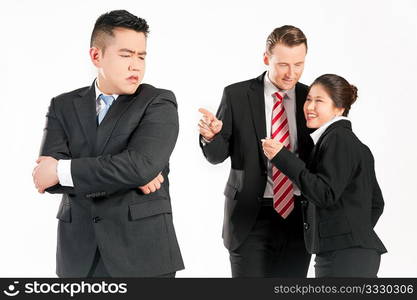 Business people (multi-ethnic) pointing their fingers on a colleague - mobbing