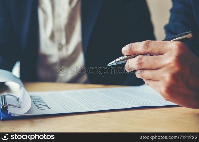 Business people negotiating a contract between two colleagues