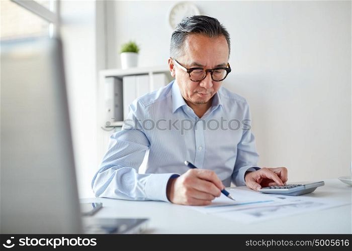 business, people, paperwork and technology concept - businessman with calculator and paper working in office. businessman with calculator and papers at office
