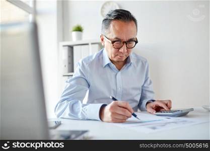 business, people, paperwork and technology concept - businessman with calculator and paper working in office. businessman with calculator and papers at office