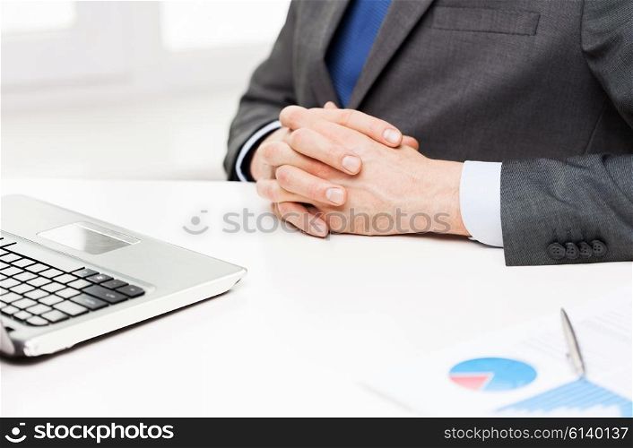 business, people, paperwork and technology concept - close up of businessman with laptop and papers in office