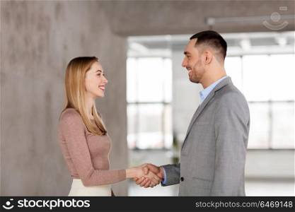 business people, partnership and cooperation concept - happy smiling businesswoman and businessman at office. smiling businesswoman and businessman at office