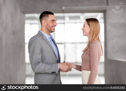 business people, partnership and cooperation concept - happy smiling businesswoman and businessman at office. smiling businesswoman and businessman at office