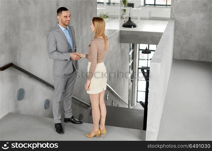 business people, partnership and cooperation concept - happy smiling businesswoman and businessman at office. smiling businesswoman and businessman at office. smiling businesswoman and businessman at office