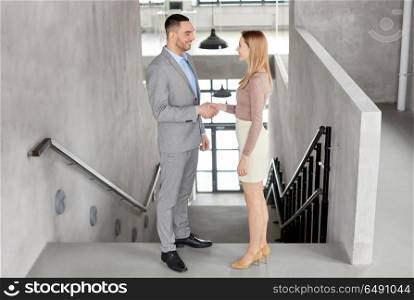 business people, partnership and cooperation concept - happy smiling businesswoman and businessman at office. smiling businesswoman and businessman at office. smiling businesswoman and businessman at office