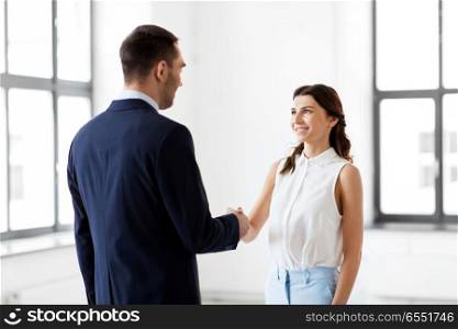 business people, partnership and cooperation concept - happy smiling businesswoman and businessman shake hands at office. businesswoman and businessman shake hands. businesswoman and businessman shake hands