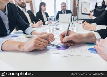 Business people pointing at diagram. Business people with pens pointing at diagram on business document at meeting