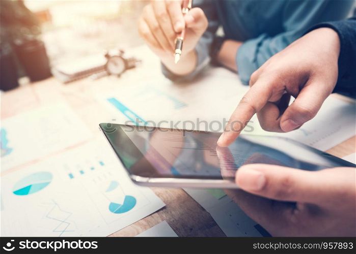 Business people pointing chart on tablet screen with analysis together.