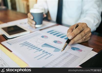 Business people pointing on statistic number result and analysis finance cost with checking summary reports graph in office.
