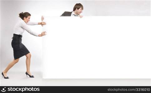 Business people pulling an empty white board, lots of copyspace