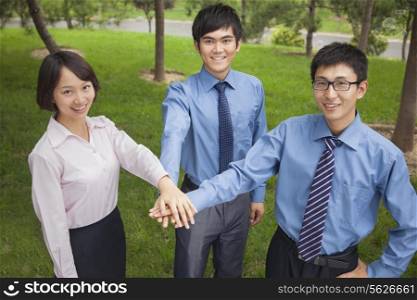 Business people putting their hand together as sign of team working