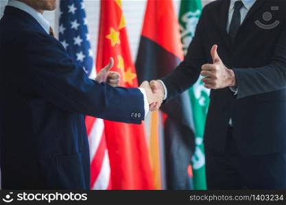 Business people shake hands, international flag background