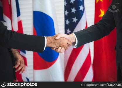Business people shake hands, international flag background