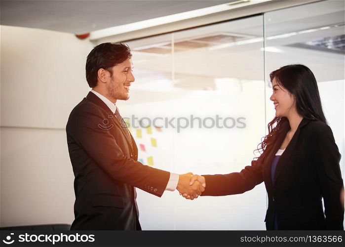 Business people shaking hands and smiling their agreement to sign contract and finishing up a meeting
