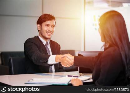 Business people shaking hands and smiling their agreement to sign contract and finishing up a meeting