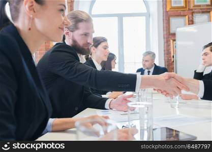 Business people shaking hands. Business people shaking hands at meeting in office after discussion of financial charts
