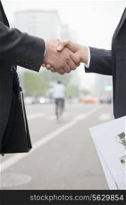 Business People Shaking Hands On Road