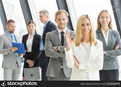 Business people showing ok. Successful young business people showing ok sign