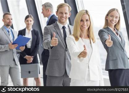 Business people showing thumbs up. Successful young business people showing thumbs up sign