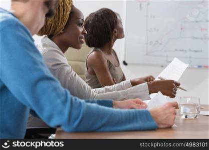 Business people sitting in a row and working, focus on pretty african woman. Multi ethnic group of people