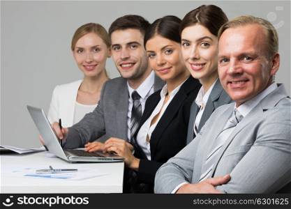 Business people sitting in a row. Business people sitting in a row and working with documents and laptop