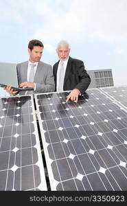 Business people standing by solar panels