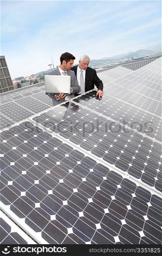 Business people standing by solar panels