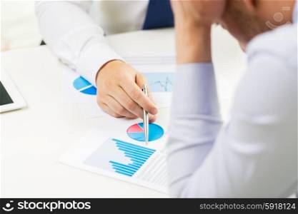 business, people, statistics and fail concept - close up of businessman hands showing chart to other anxious man man at office