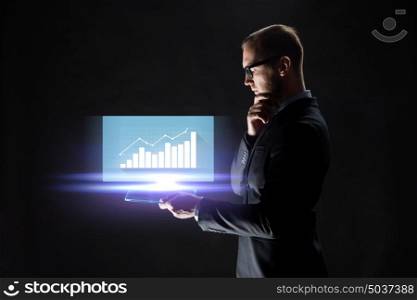 business, people, statistics and future technology concept -businessman with transparent tablet pc computer and virtual diagram chart over black background. businessman with tablet pc and virtual chart