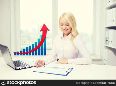 business, people, statistics and technology concept - smiling businesswoman with laptop computer, papers and growing chart sitting in office