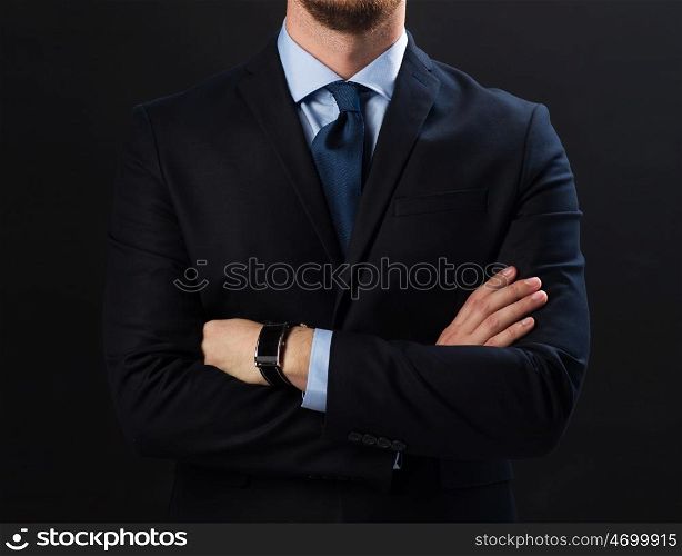 business people, style and office worker concept - businessman in suit and smartwatch over black background