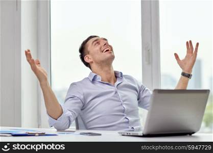 business, people, success and gladness concept - happy businessman with laptop in office