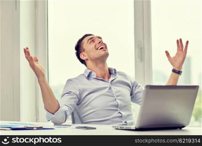 business, people, success and gladness concept - happy businessman with laptop in office