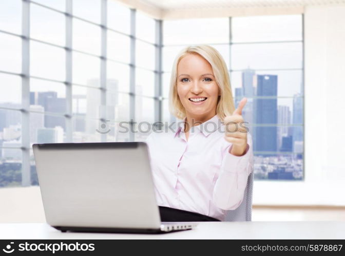 business, people, success, gesture and technology concept - smiling businesswoman or student showing thumbs up with laptop computer in office