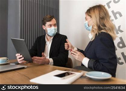 business people talking about new project while wearing medical masks