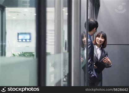 Business people talking together by a glass wall