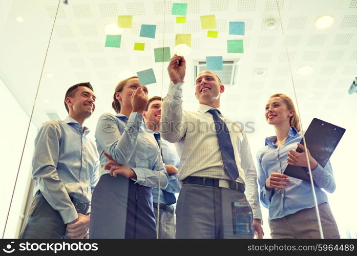 business, people, teamwork and planning concept - smiling business team with marker and stickers working in office