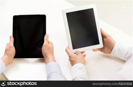 business, people, technology, advertisement and teamwork concept - close up of businessman hands with tablet pc computer blank screens at office