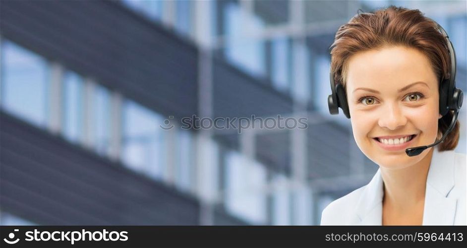 business, people, technology and communication concept - happy female helpline operator in headset over city office building background