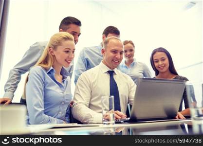business, people, technology and communication concept - smiling business team with laptop computer making video conference in office