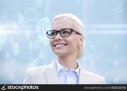 business, people, technology and communication concept - young smiling businesswoman in eyeglasses looking to network hologram outdoors