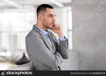 business people, technology and corporate concept - businessman calling on smartphone at office. businessman calling on smartphone at office
