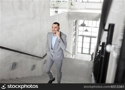 business people, technology and corporate concept - businessman calling on smartphone at office. businessman calling on smartphone at office. businessman calling on smartphone at office