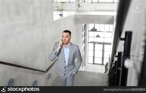 business people, technology and corporate concept - businessman calling on smartphone at office. businessman calling on smartphone at office. businessman calling on smartphone at office