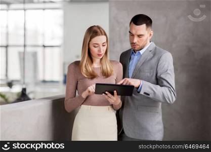 business people, technology and corporate concept - businesswoman and businessman with tablet pc computer at office. businesswoman and businessman with tablet pc