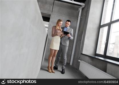 business people, technology and corporate concept - businesswoman and businessman with tablet pc computer at office. businesswoman and businessman with tablet pc. businesswoman and businessman with tablet pc