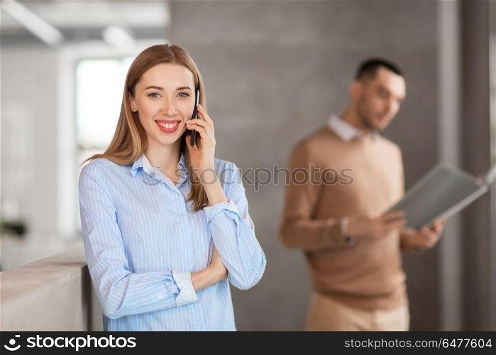 business people, technology and corporate concept - businesswoman calling on smartphone at office. businesswoman calling on smartphone at office. businesswoman calling on smartphone at office